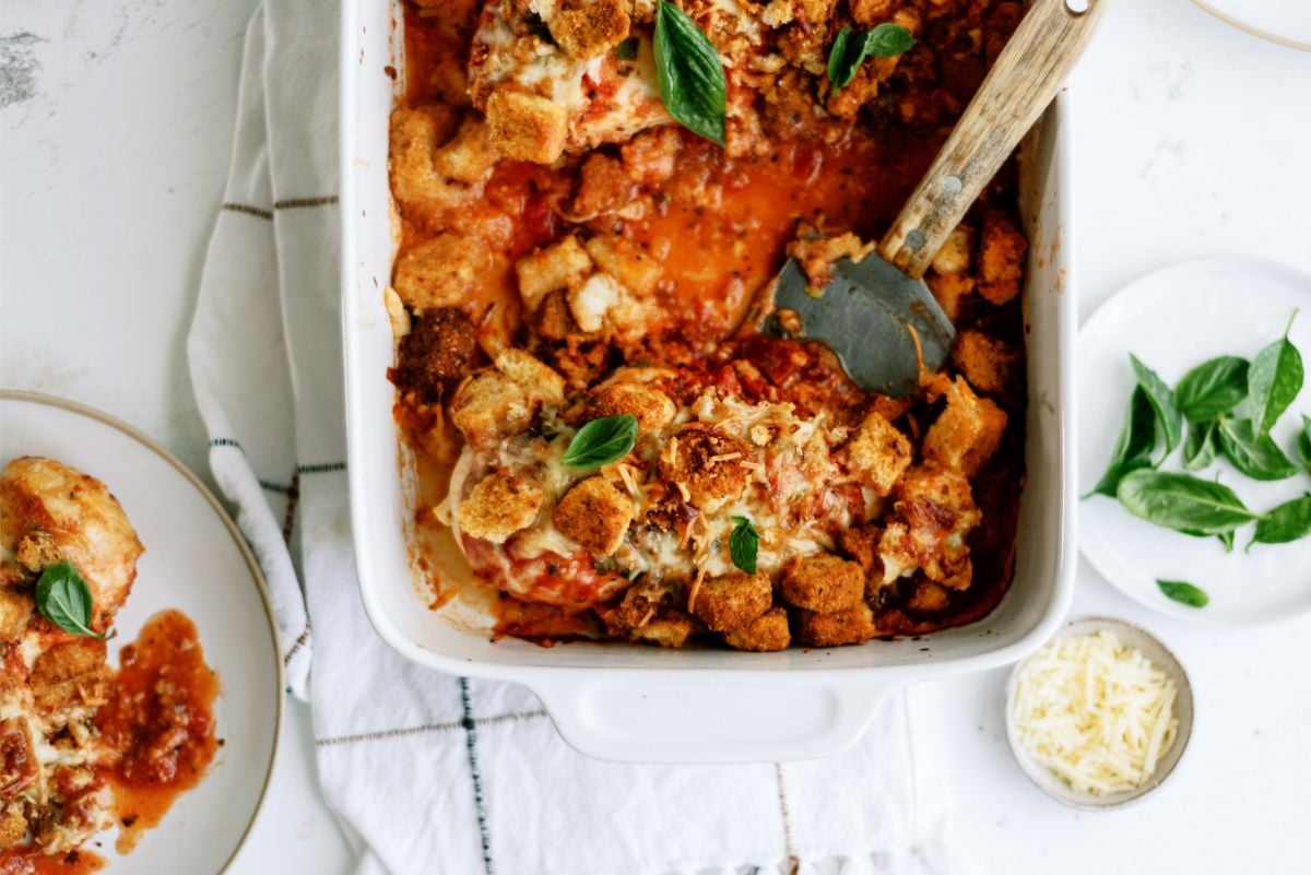 Top view of Baked Chicken Parmesan Casserole in casserole dish with a serving utencil