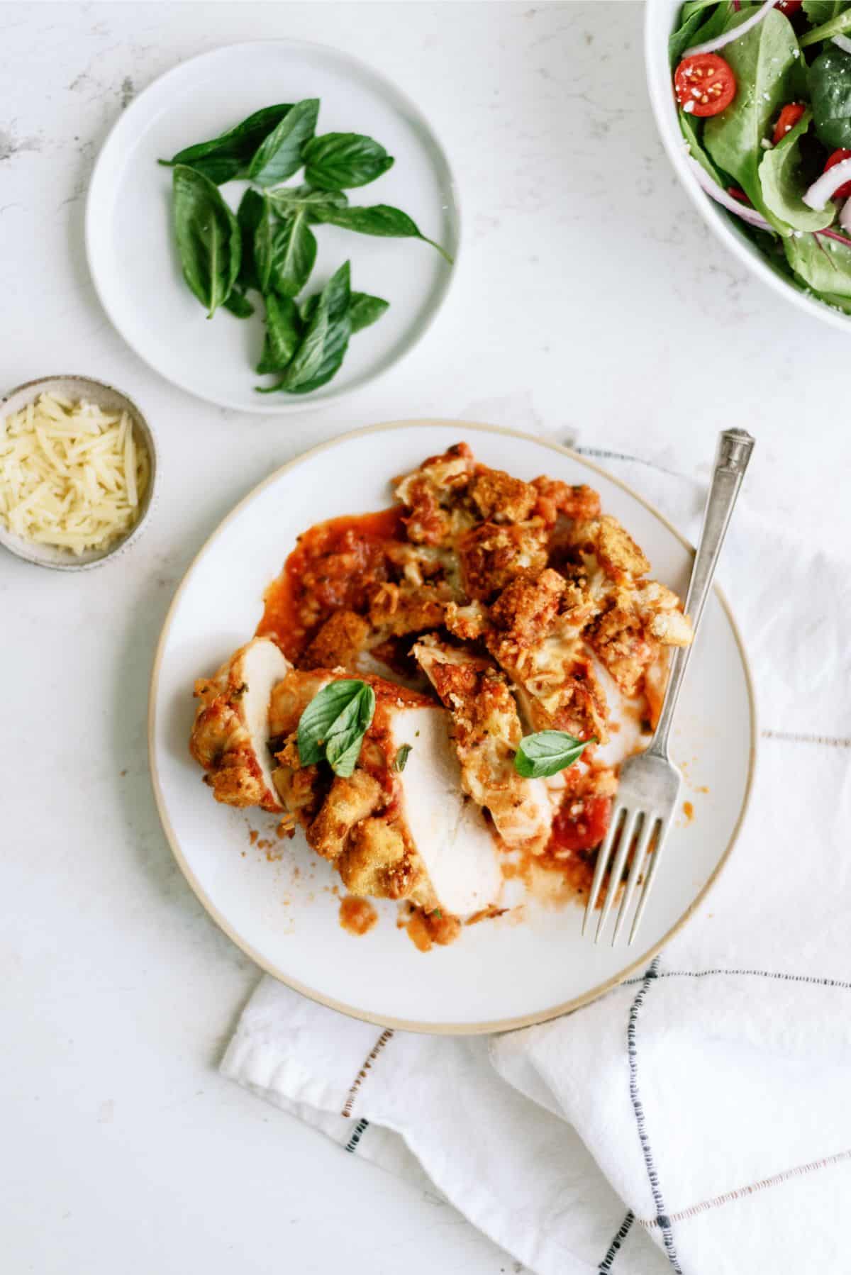 Top view of a serving of Baked Chicken Parmesan Casserole on a plate with a fork