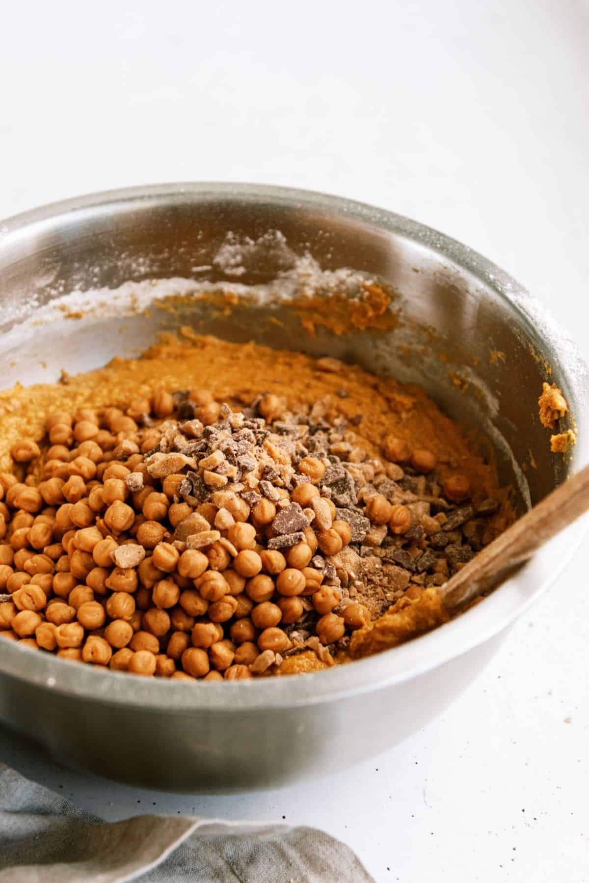 Adding heath bits and caramel bits to bowl with cake batter