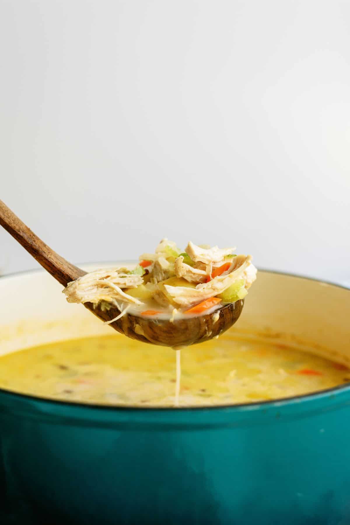 A ladle lifting a scoop of Creamy Chicken and Potato Soup out of the pot.