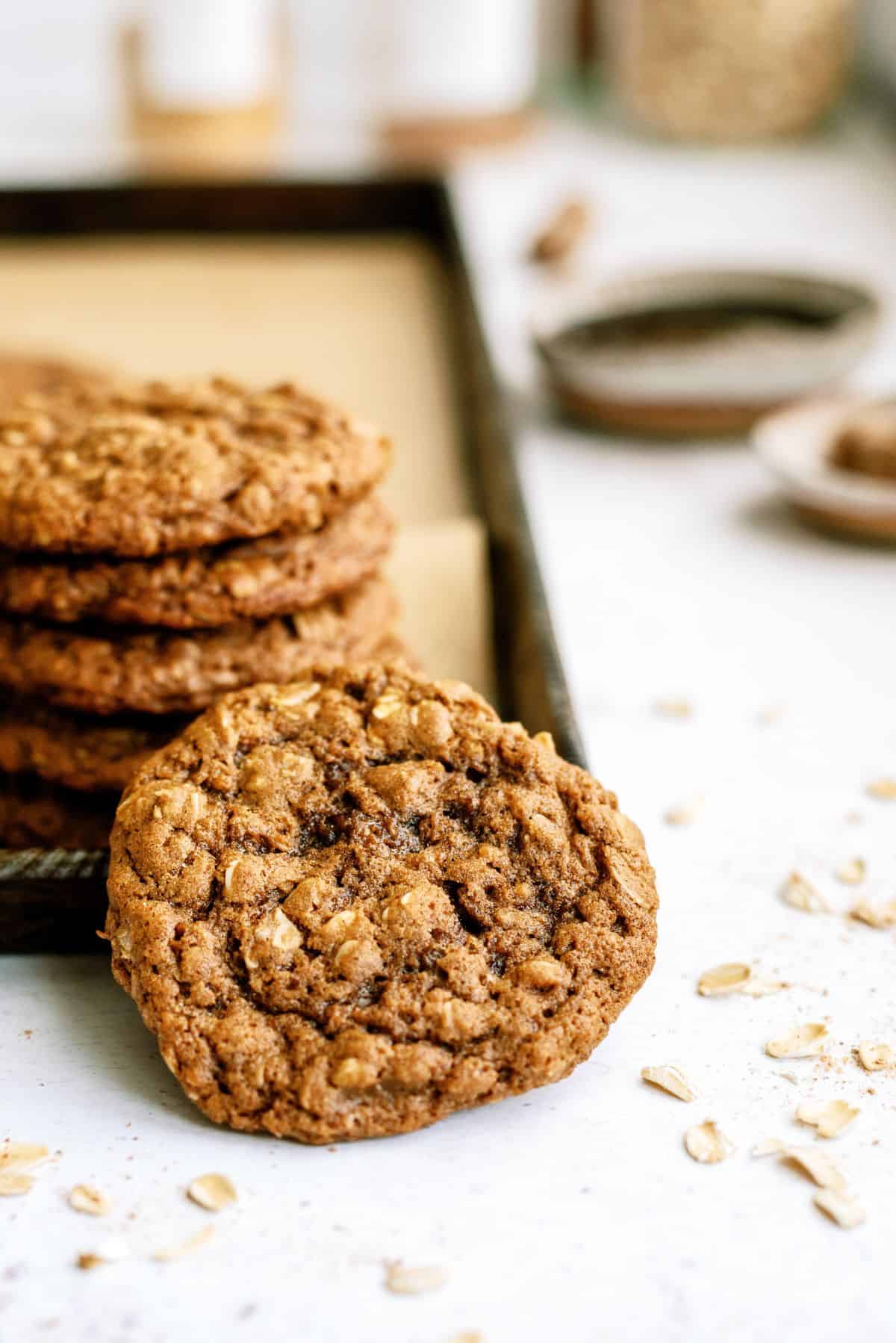 Oatmeal Gingerbread Cookies stacked on a baking sheet