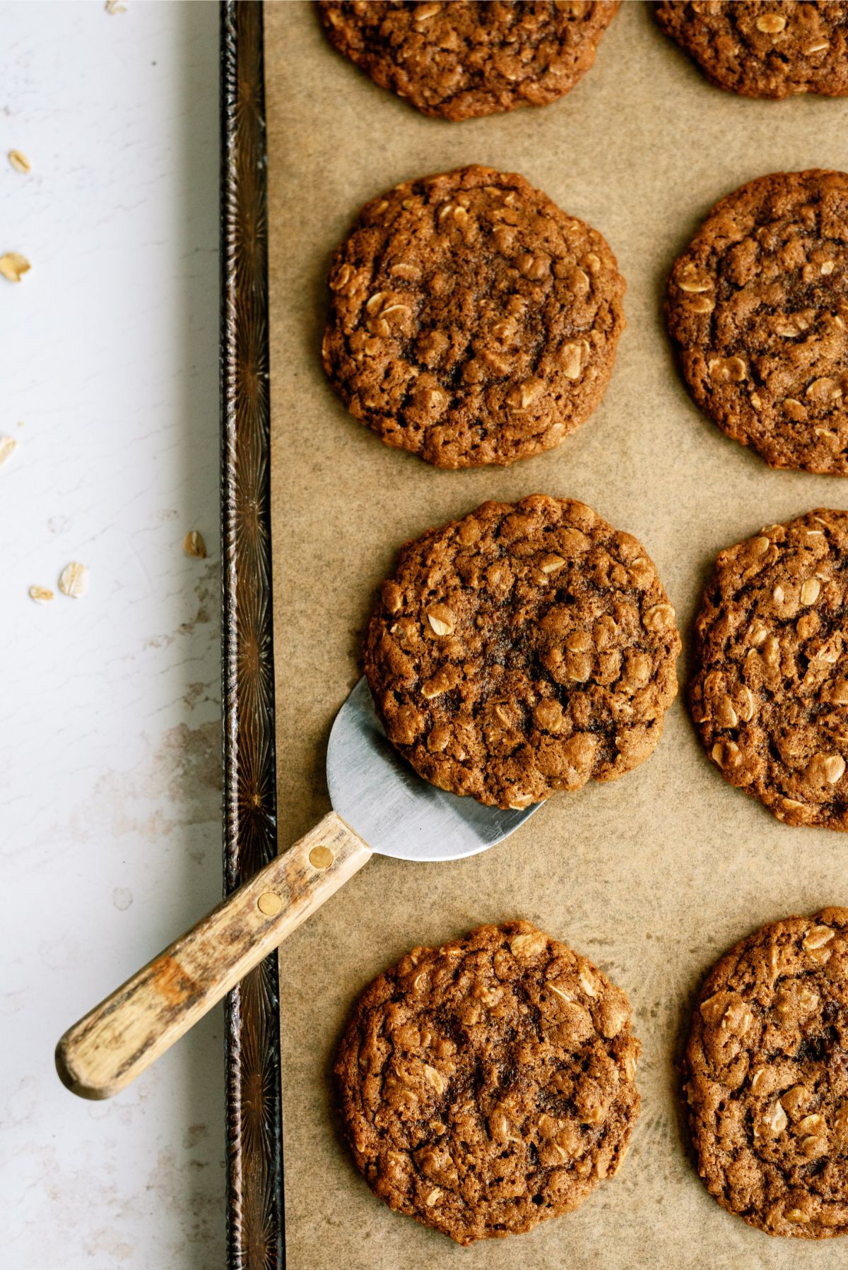 A spatula lifting Oatmeal Gingerbread Cookie off the cookie sheet