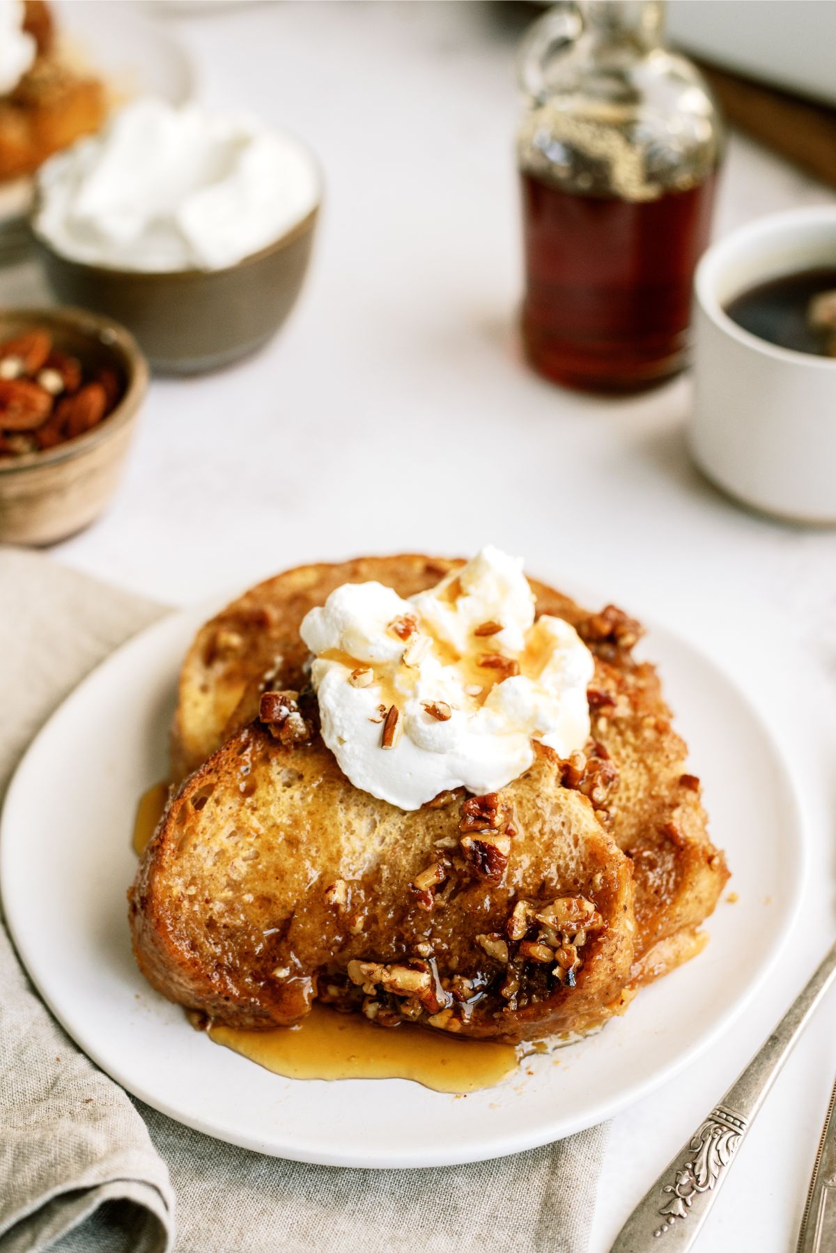 Overnight Praline Pecan French Toast Bake on a plate topped with whip cream