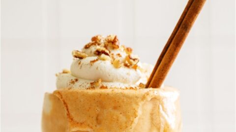 Pumpkin Pie Milkshakes topped with whip cream and a cinnamon stick.