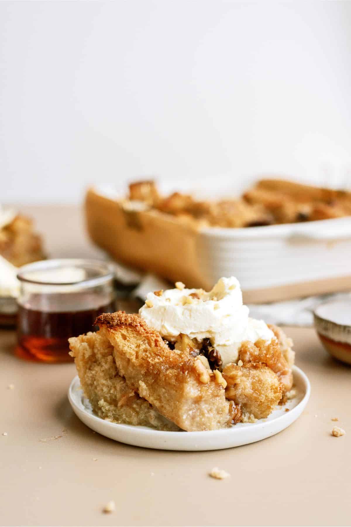 Slice of Brown Sugar and Maple Bread Pudding on a plate with toppings