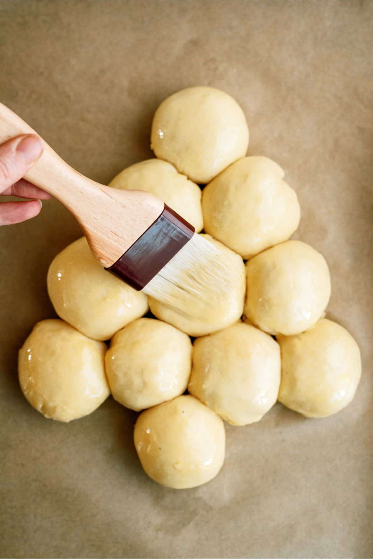 Brushing unbaked rolls with egg wash mixture