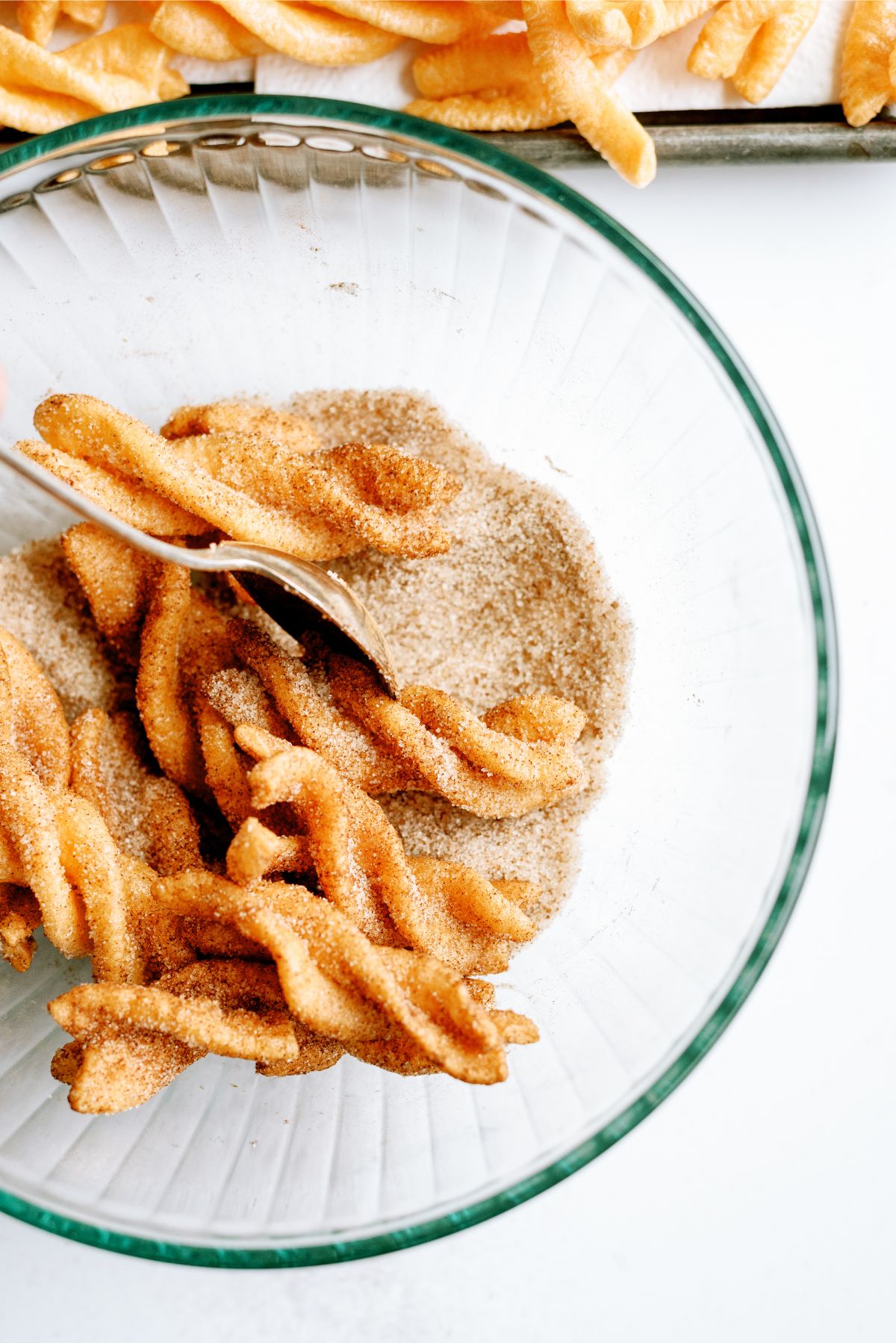 Duros tossed in a bowl of cinnamon and sugar