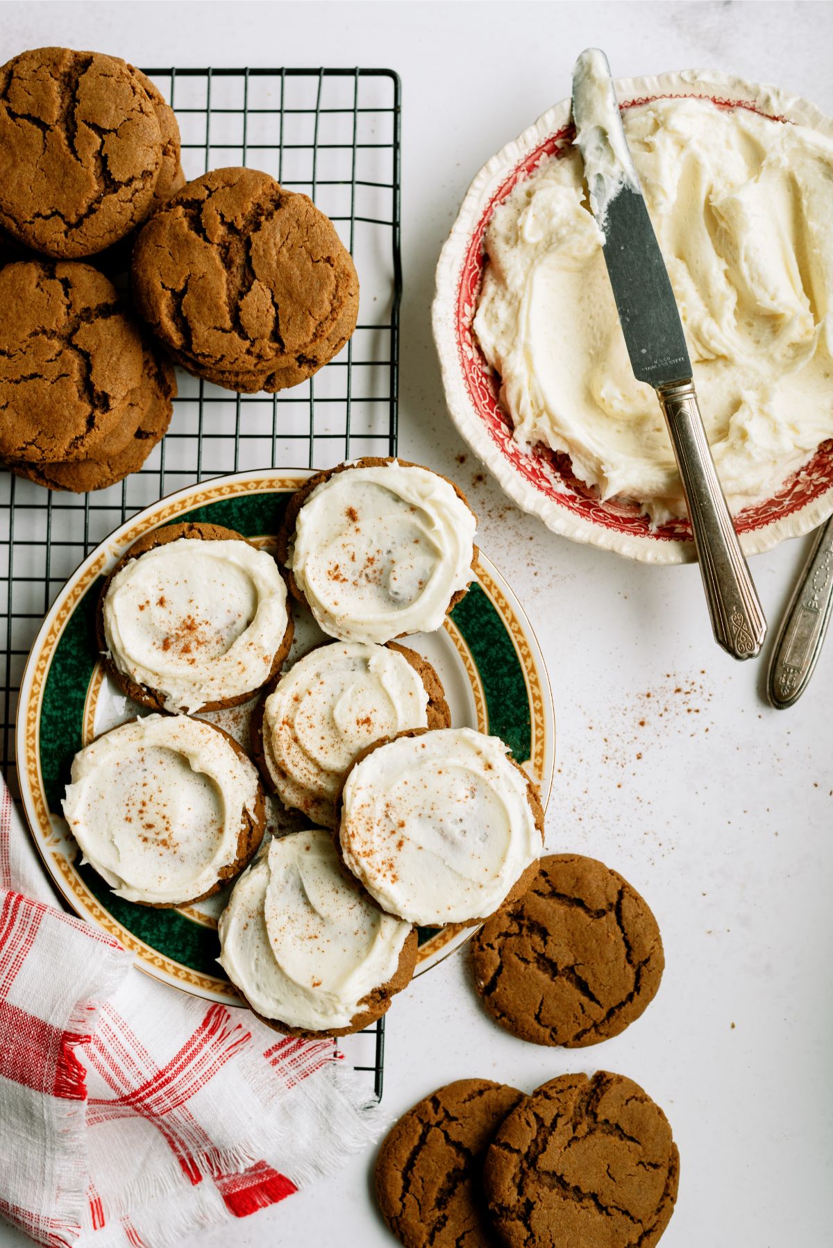 A plate of Ginger Cookies with Eggnog Frosting, a cooling rack with Ginger Cookies and a bowl of eggnog frosting