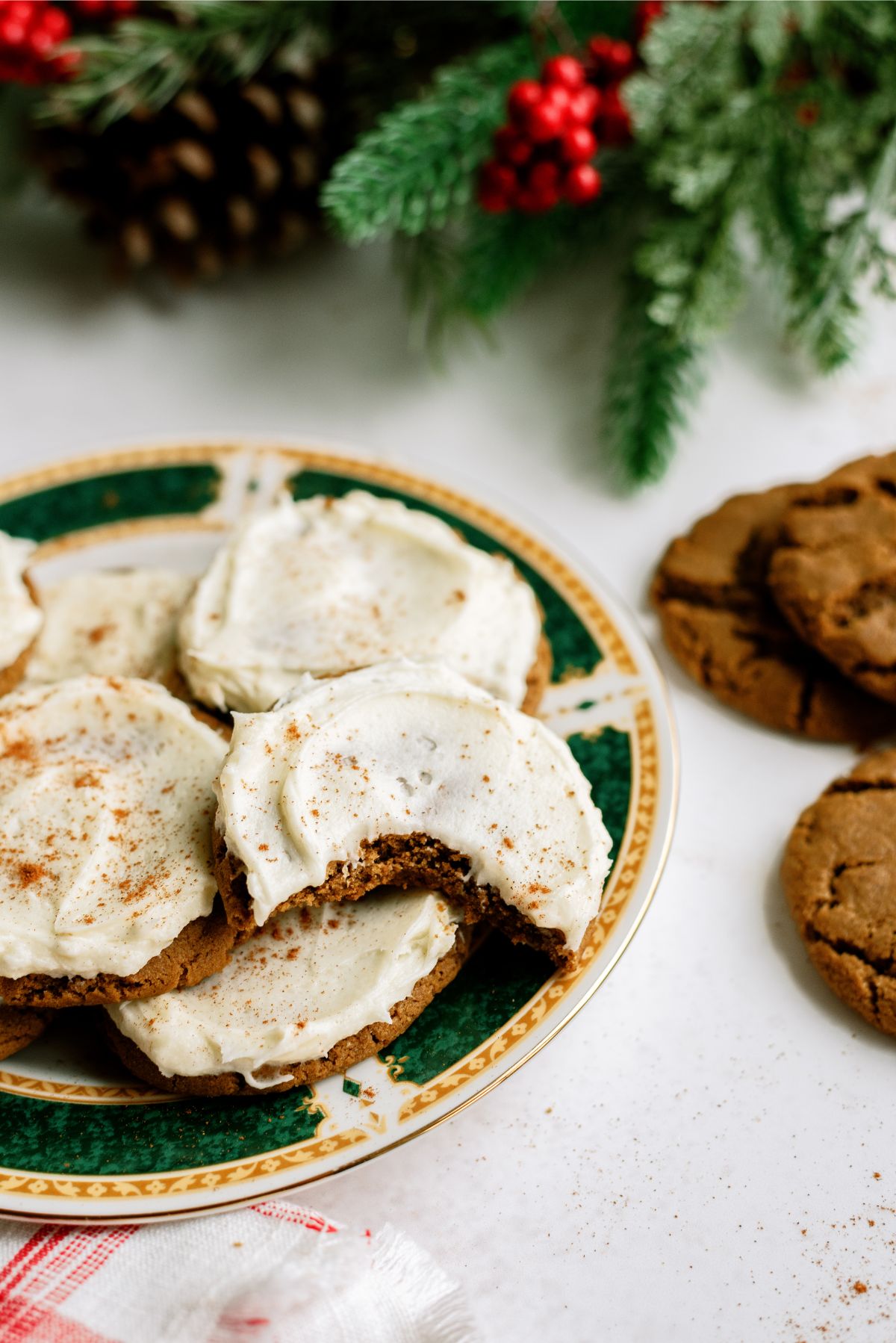 A plate of Ginger Cookies with Eggnog Frosting with one cookie missing a bite