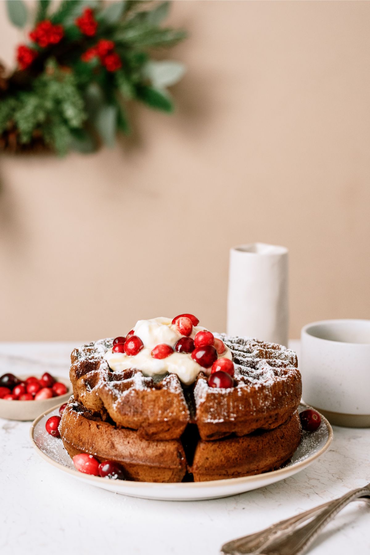 Gingerbread Waffles on a plate with whip cream and cranberries