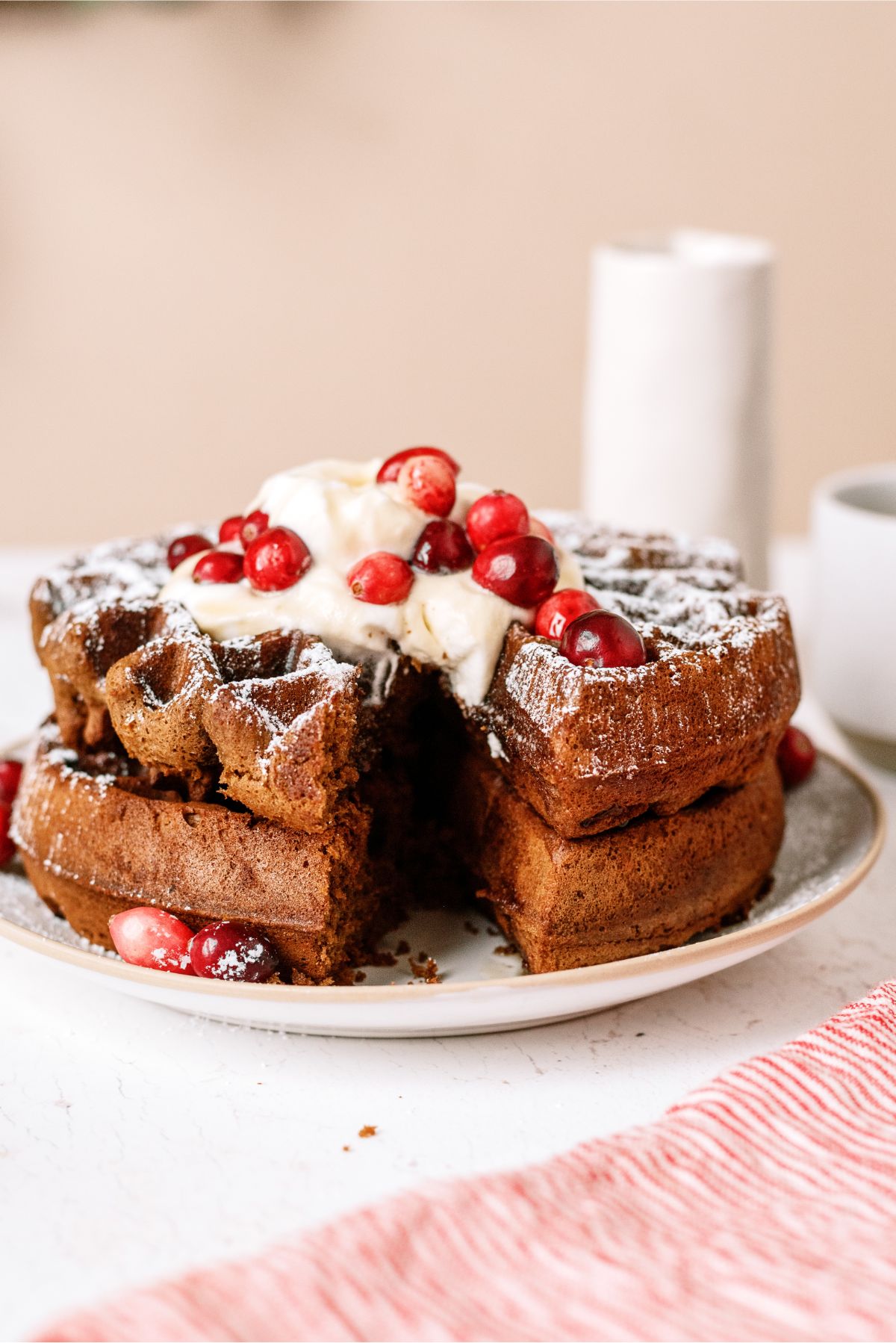 Gingerbread Waffles on a plate topped with whip cream and berries