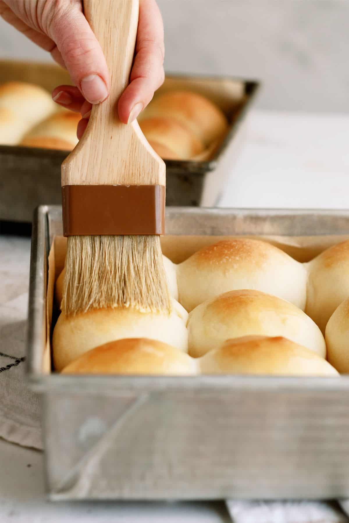 Brushing butter on fresh baked Homemade Potato Rolls