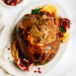 Top view of Roasted Ham Shank on a white serving platter.