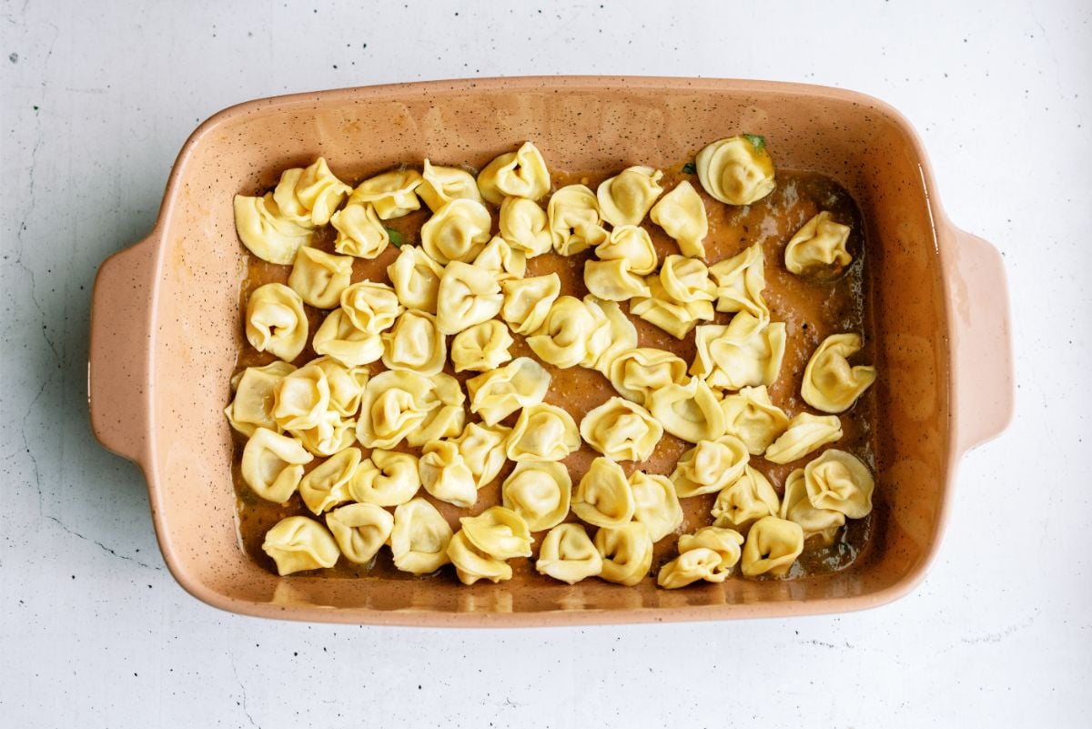 Casserole dish with sauce and tortellini