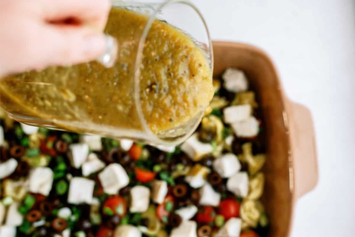 Pouring enchilada sauce over Turkey Mexican Casserole