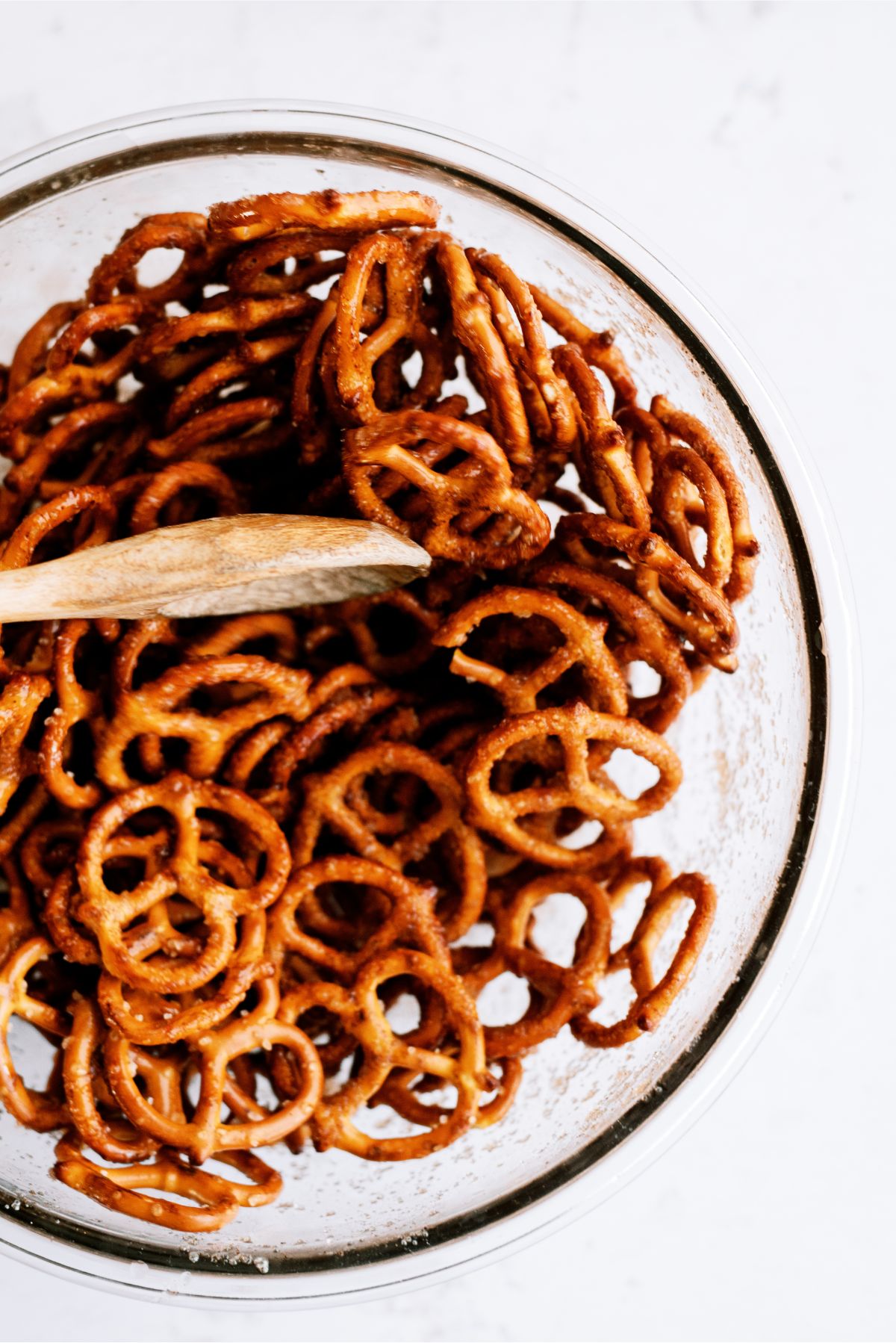 A bowl with pretzels and cinnamon sugar mix, mixed together