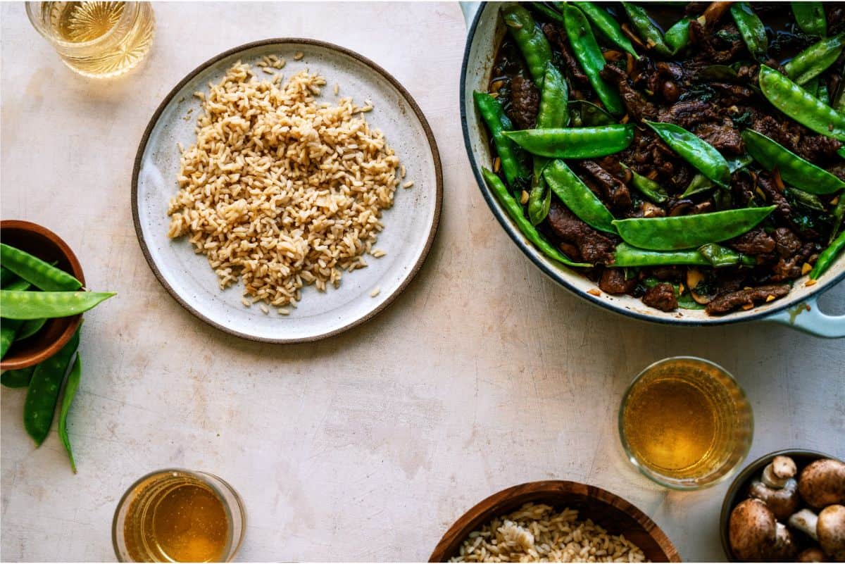 A skillet of Asian Beef and Snow Peas and a bowl of rice