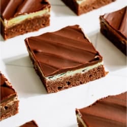 Chocolate Thin Mint Brownies cut into squares on a white background.