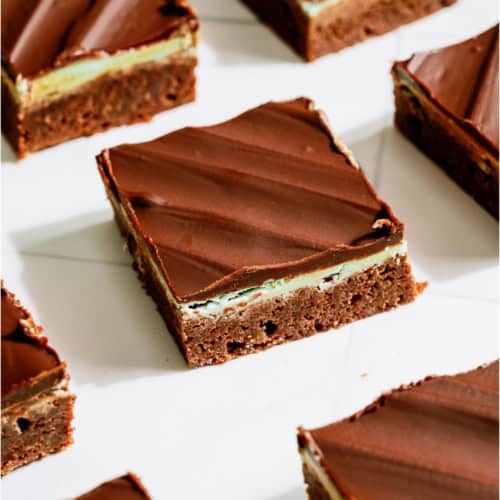 Chocolate Thin Mint Brownies cut into squares on a white background.