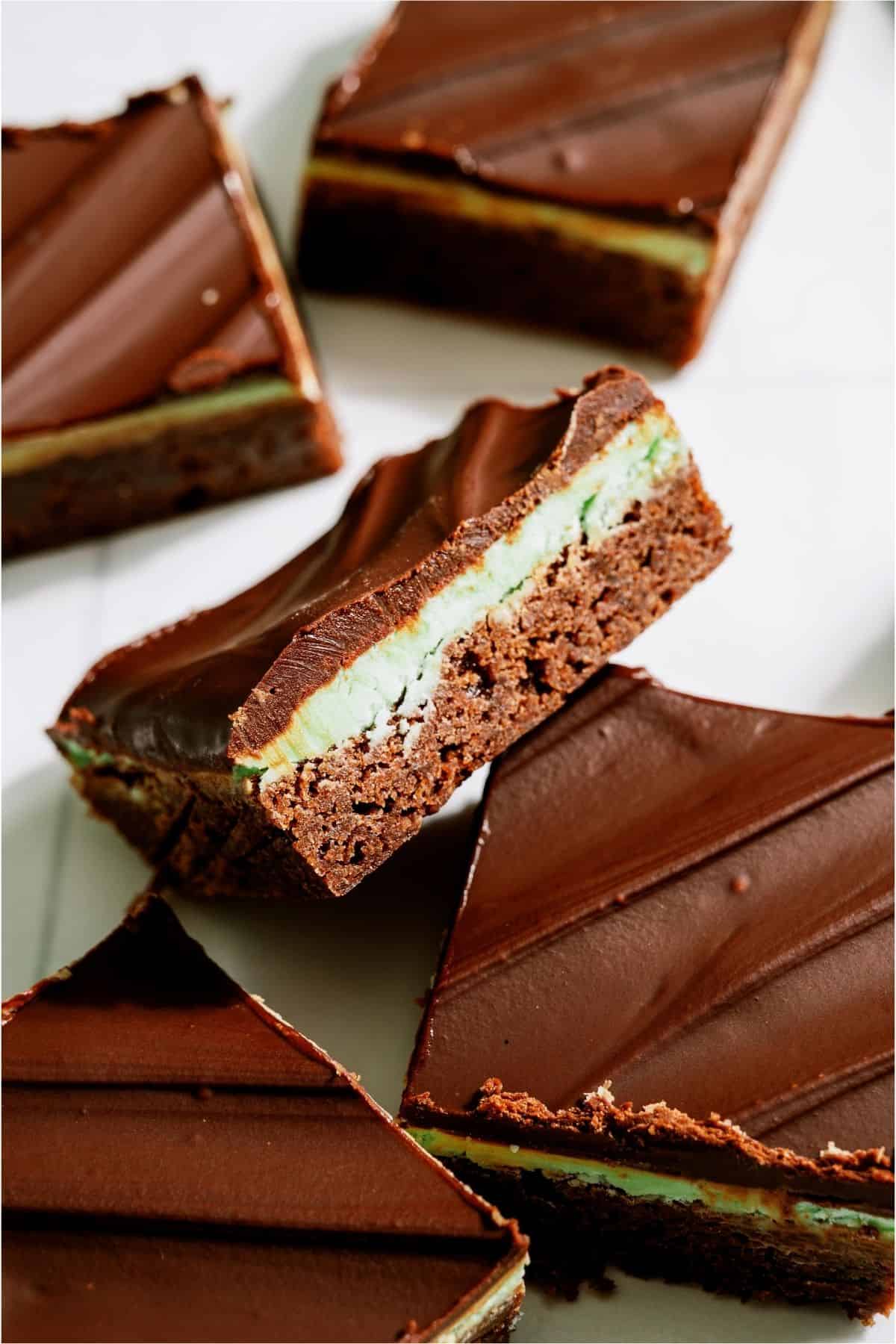Chocolate Thin Mint Brownies on a white background with one brownie tilted up.