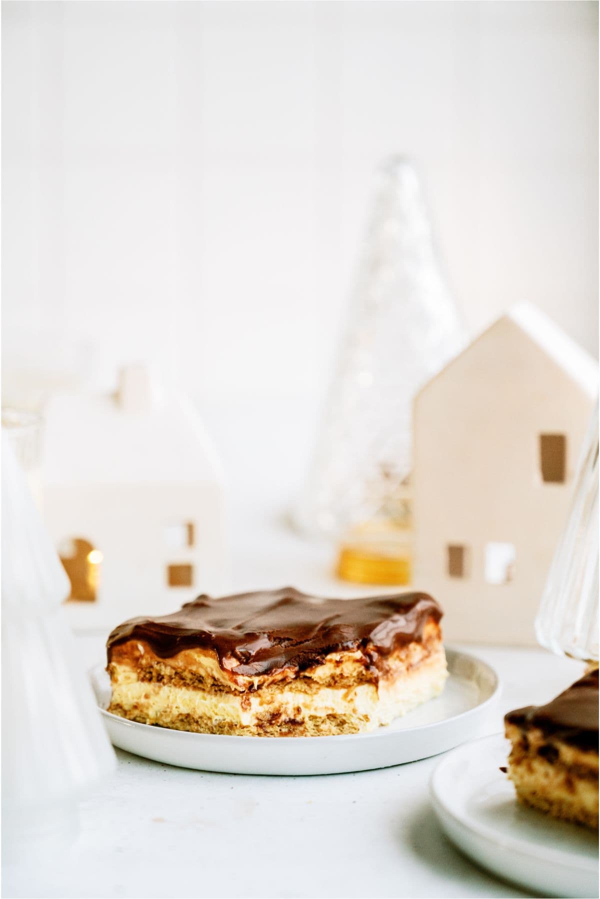 A slice of Eggnog Eclair Cake on a plate with a bite missing.