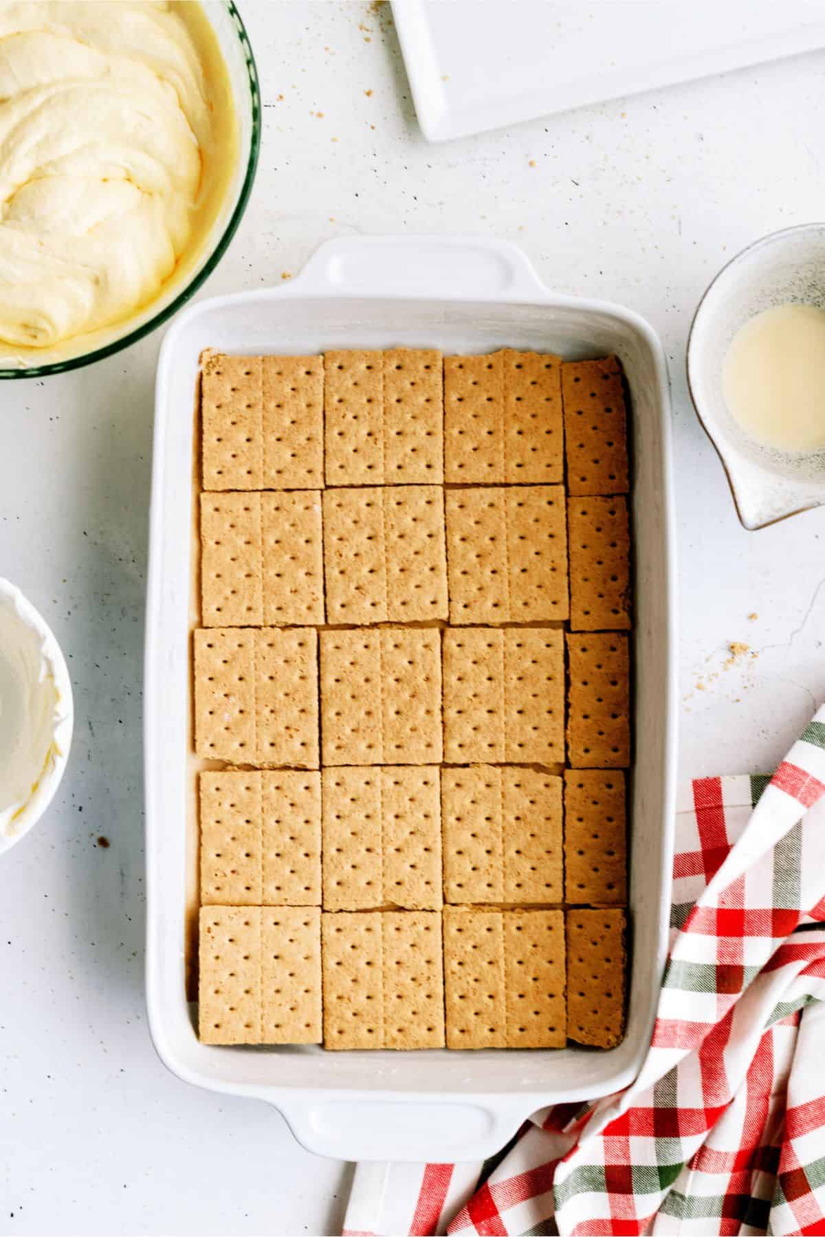 A baking dish lined with graham cracker sheets.