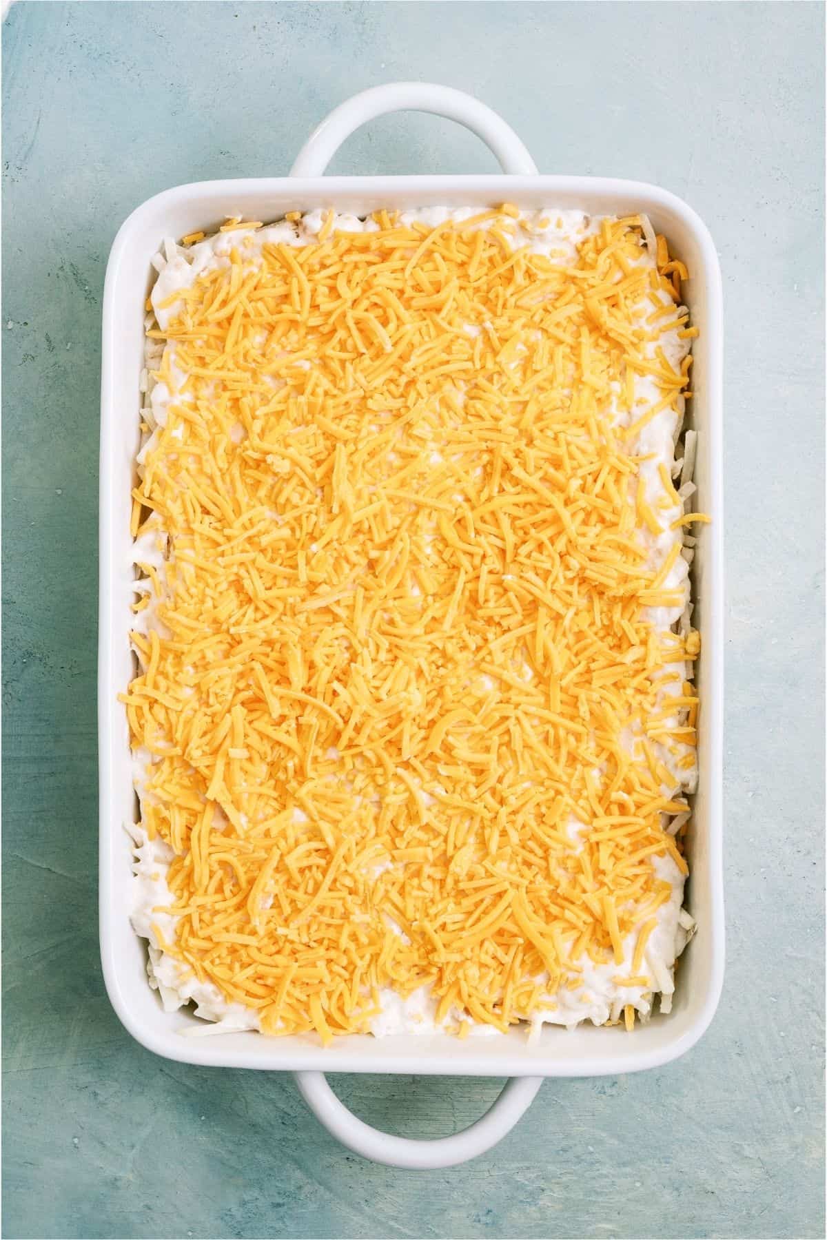 Sauce and cheese top hashbrowns in a casserole dish.