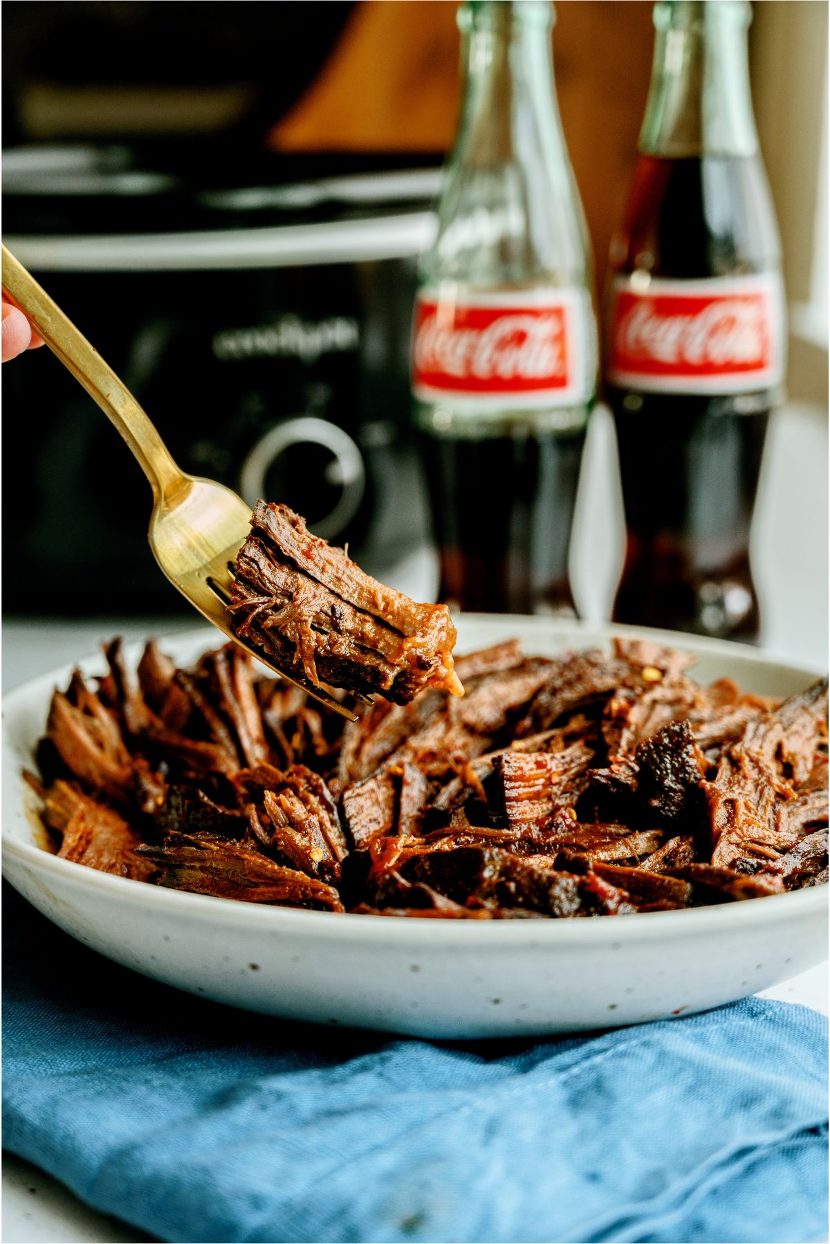 A serving of Slow Cooker Cola BBQ Roast Beef on a plate with a fork