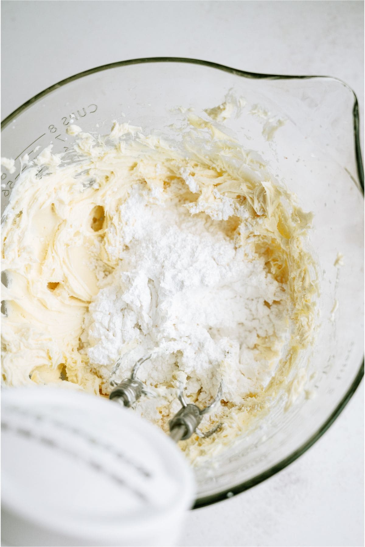 Ingredients for frosting mixed in bowl with hand mixer