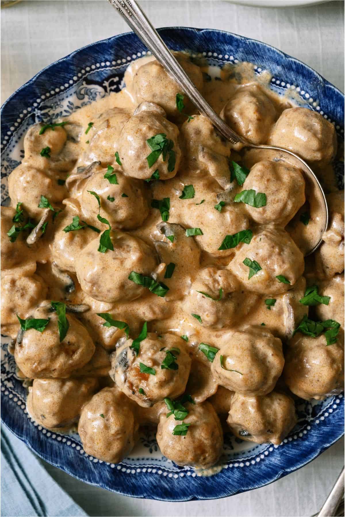 A bowl of Crock Pot Swedish Meatballs with a serving spoon.