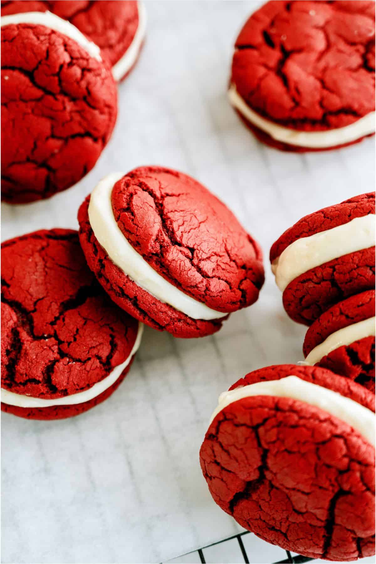 Red Velvet Whoopie Pie Sandwich Cookies on a cooling rack lined with parchment paper.
