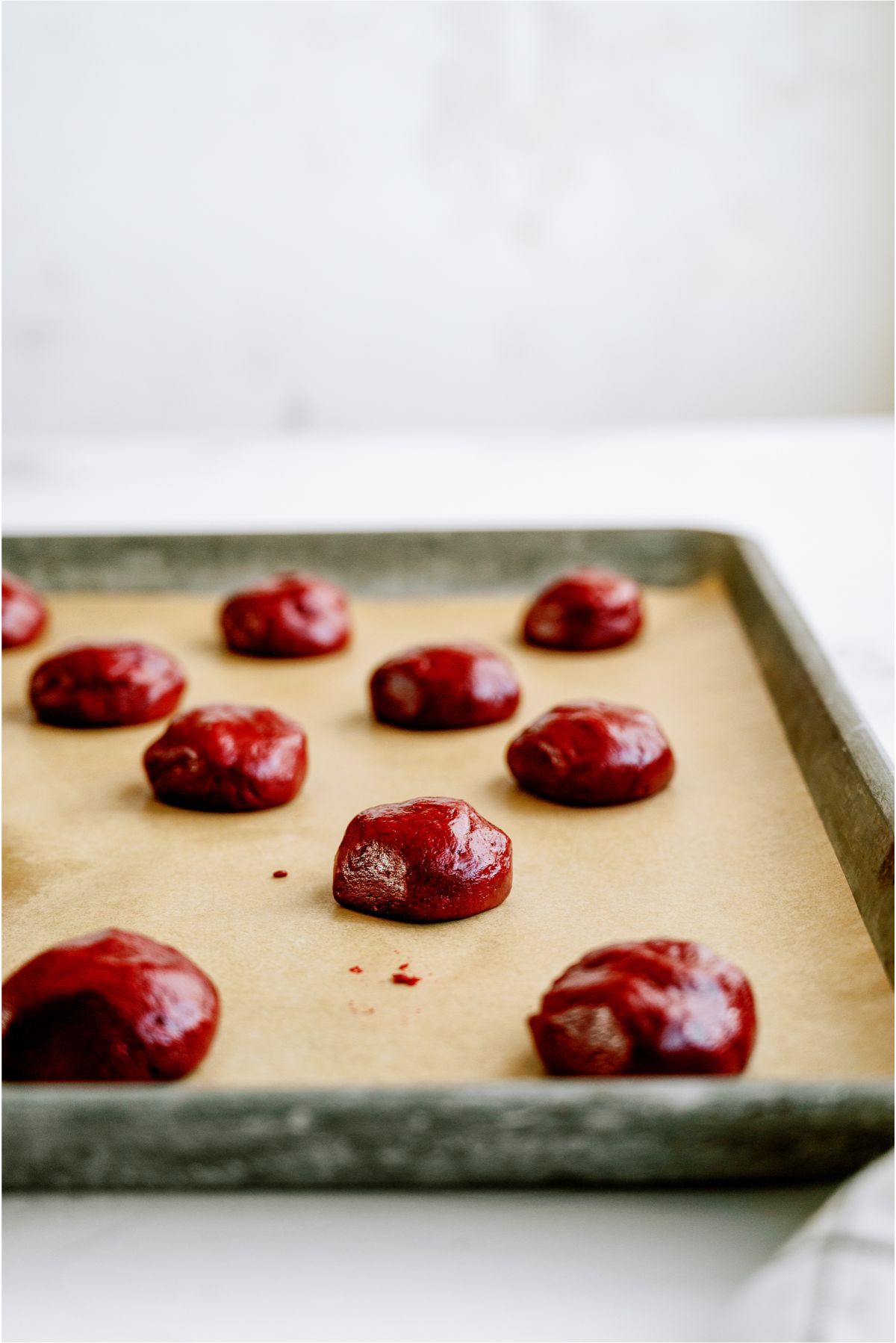 Red Velvet Whoopie Pie cookie dough balls on baking sheet