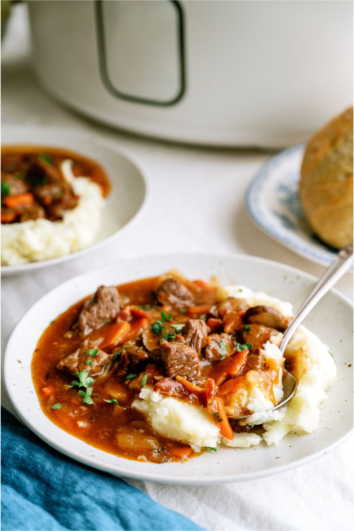 Slow Cooker Beef Bourguignon served over mashed potatoes on a plate