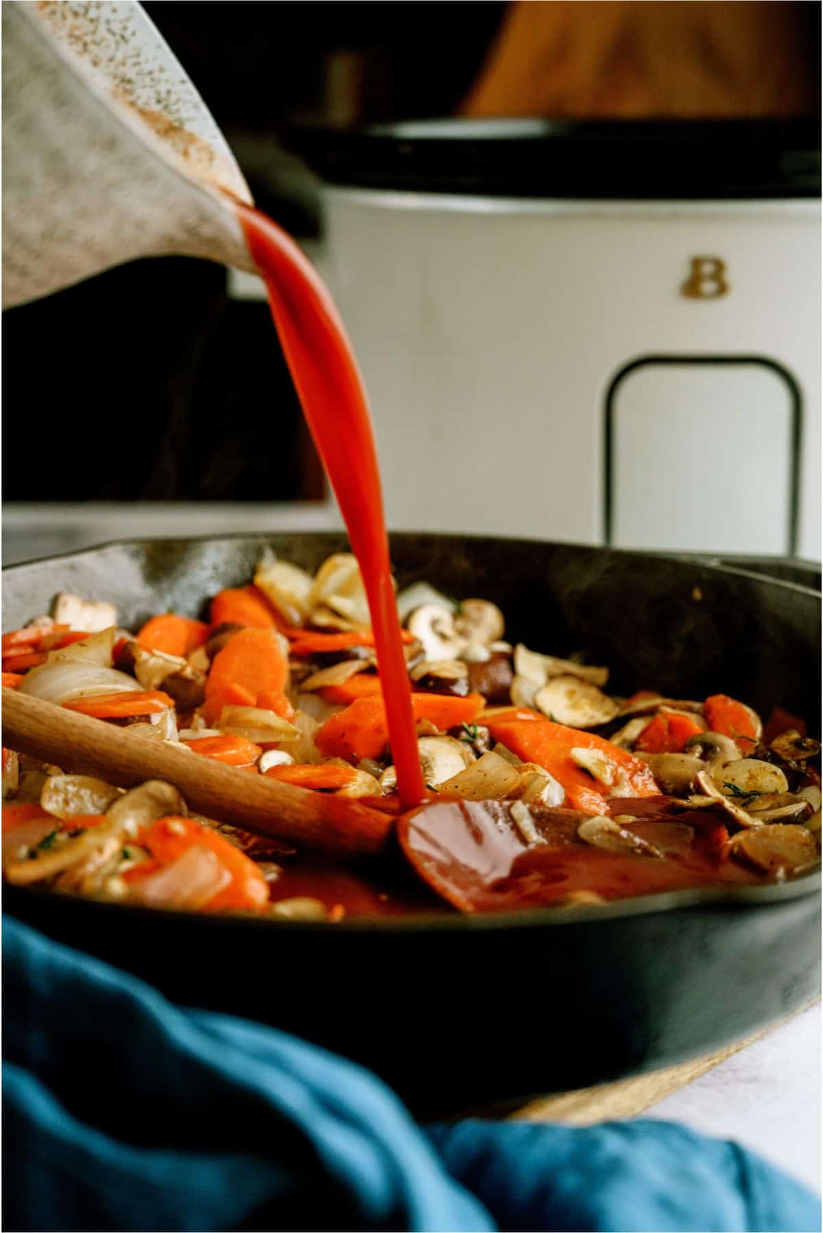 Pouring deglaze sauce into skillet with ingredients for Slow Cooker Beef Bourguignon