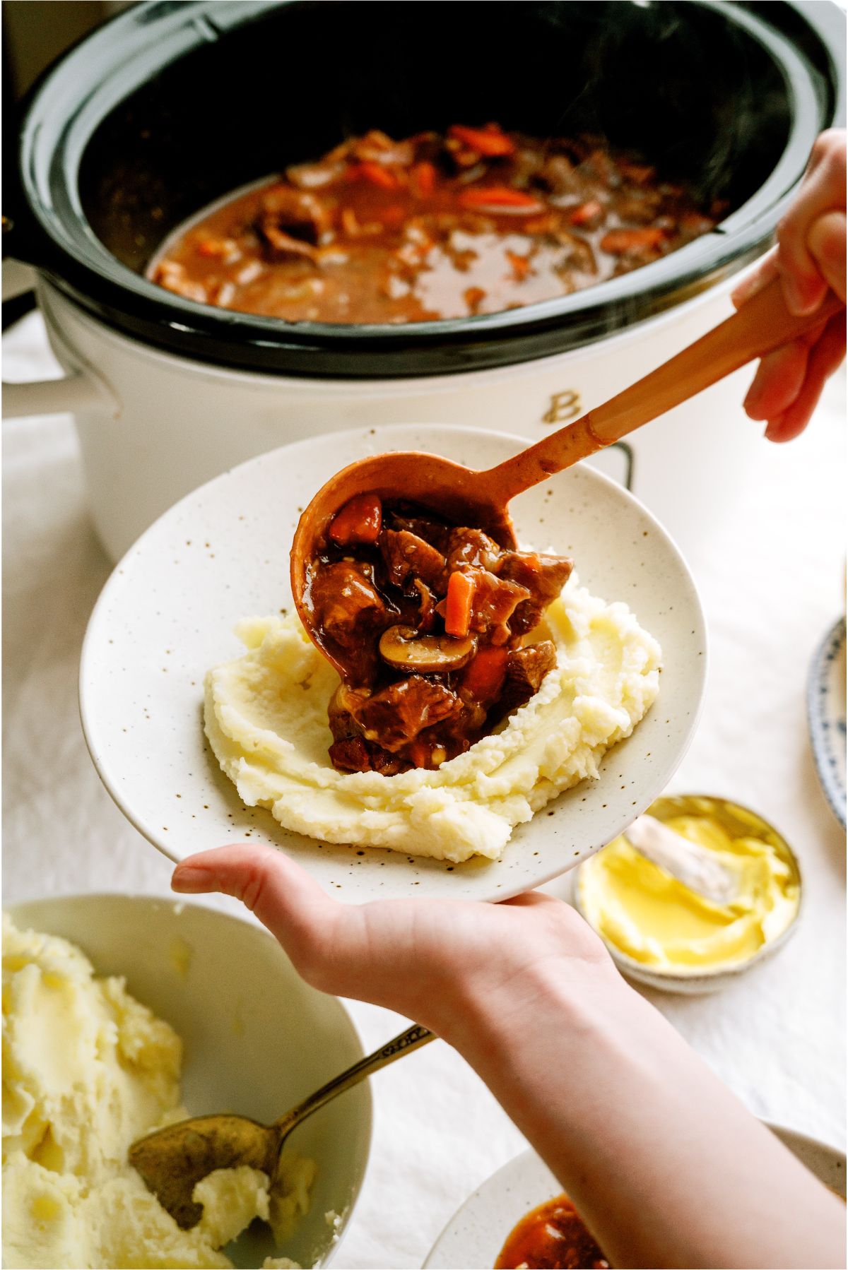 Serving Slow Cooker Beef Bourguignon over mashed potatoes