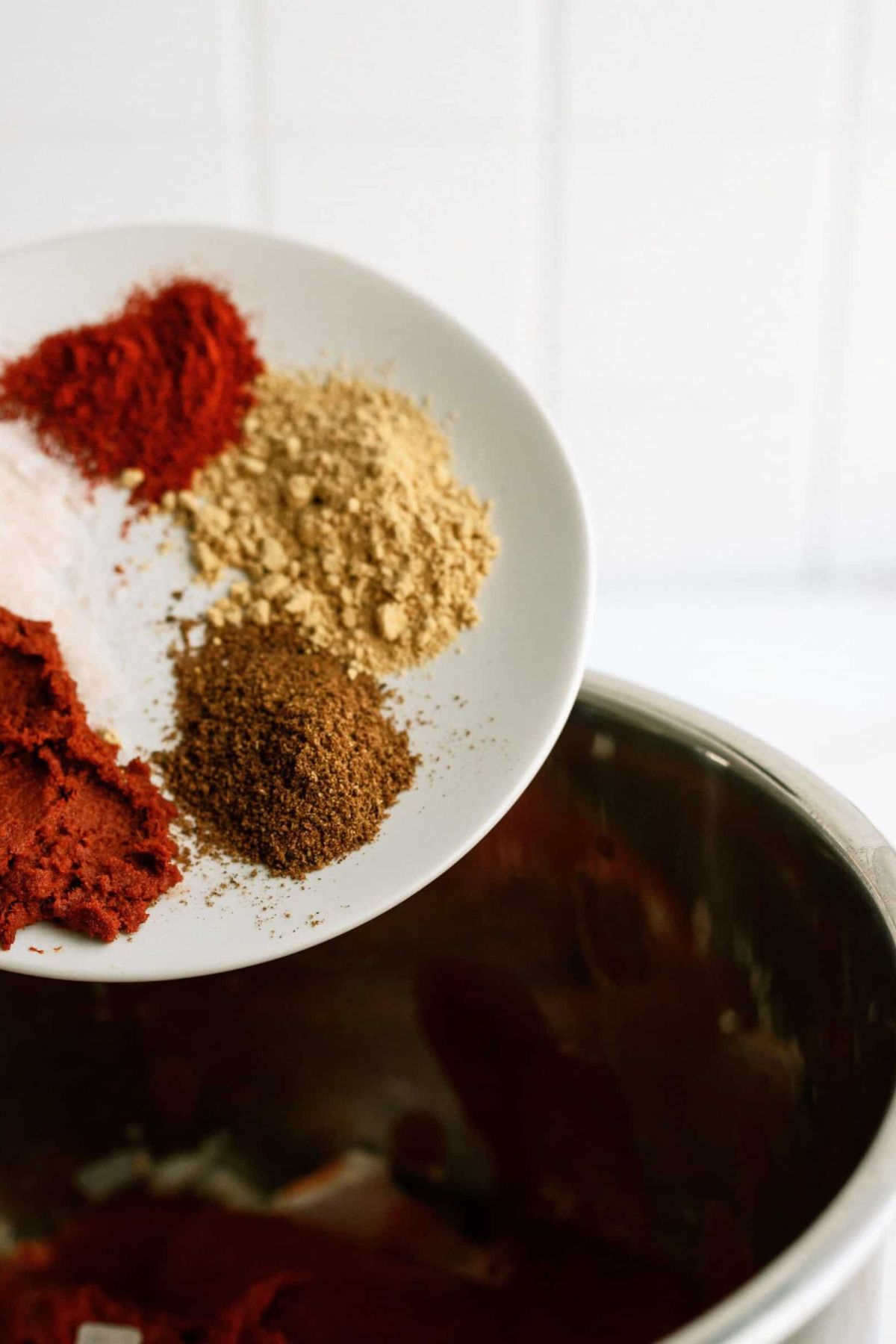 A plate holding different seasonings held over the Instant Pot.