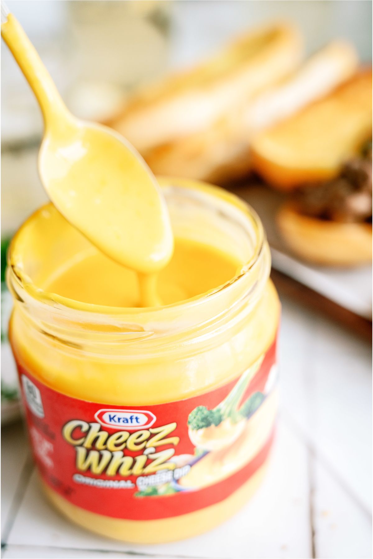 A jar of cheese whiz with a spoon