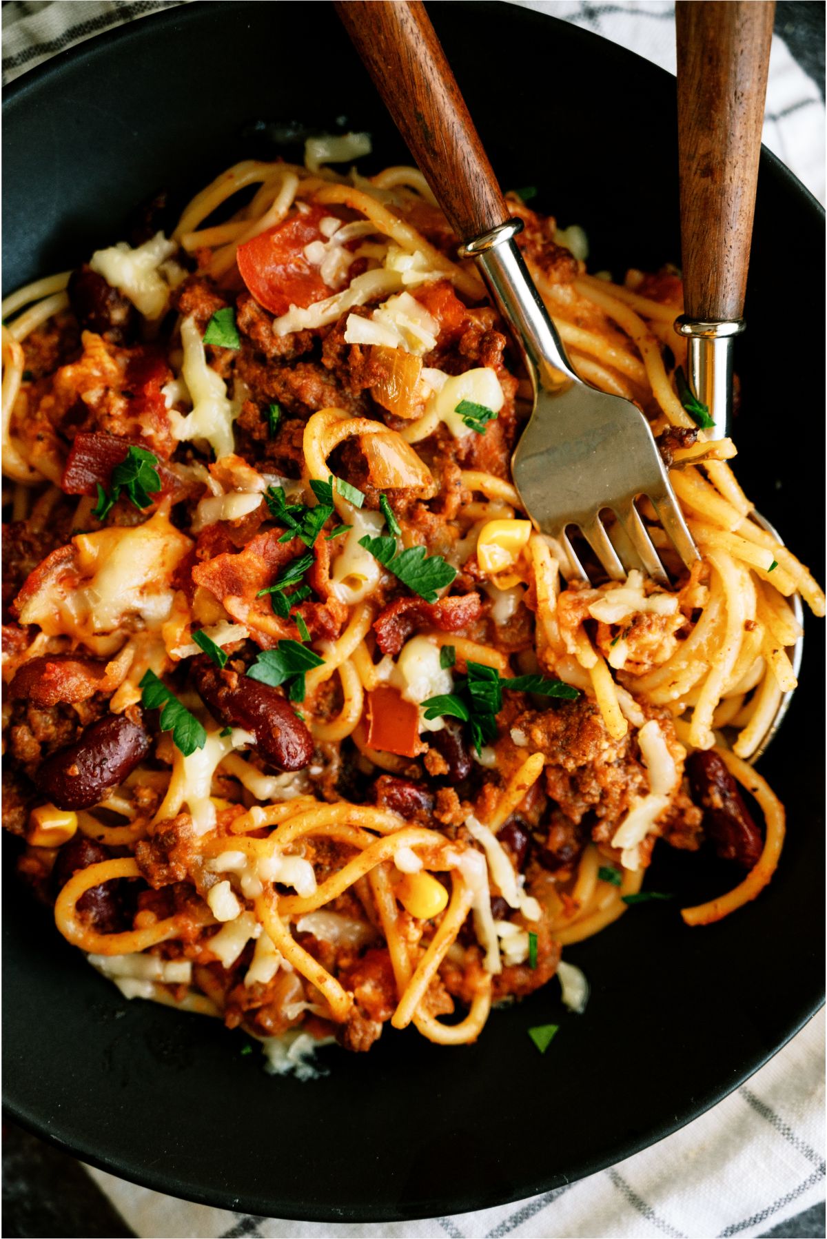 A serving of Skillet Cowboy Spaghetti on a plate with a fork and spoon