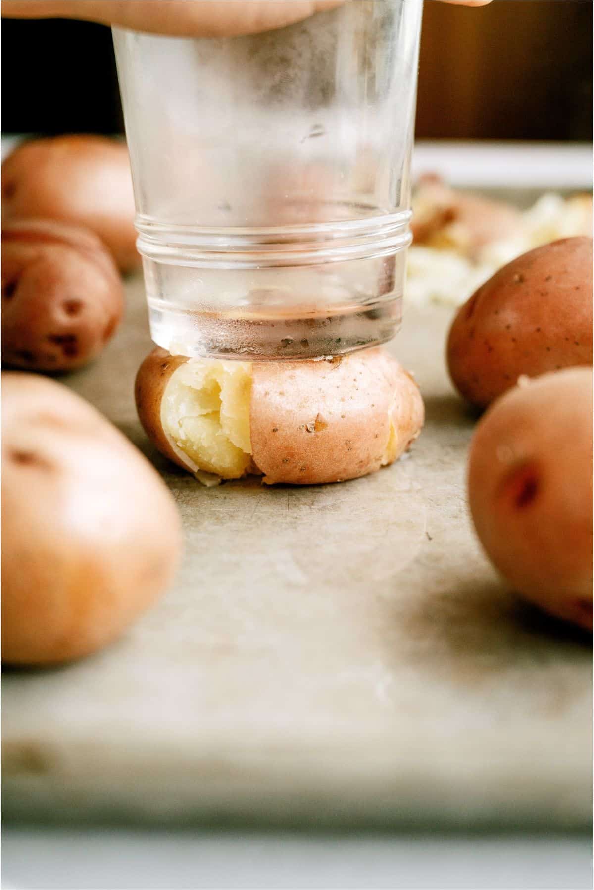 Smashing cooked potato with bottom of glass