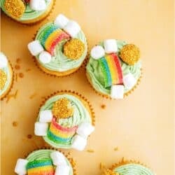 Top view of several St. Patrick's Day Cupcakes on a yellow background with gold sprinkles.