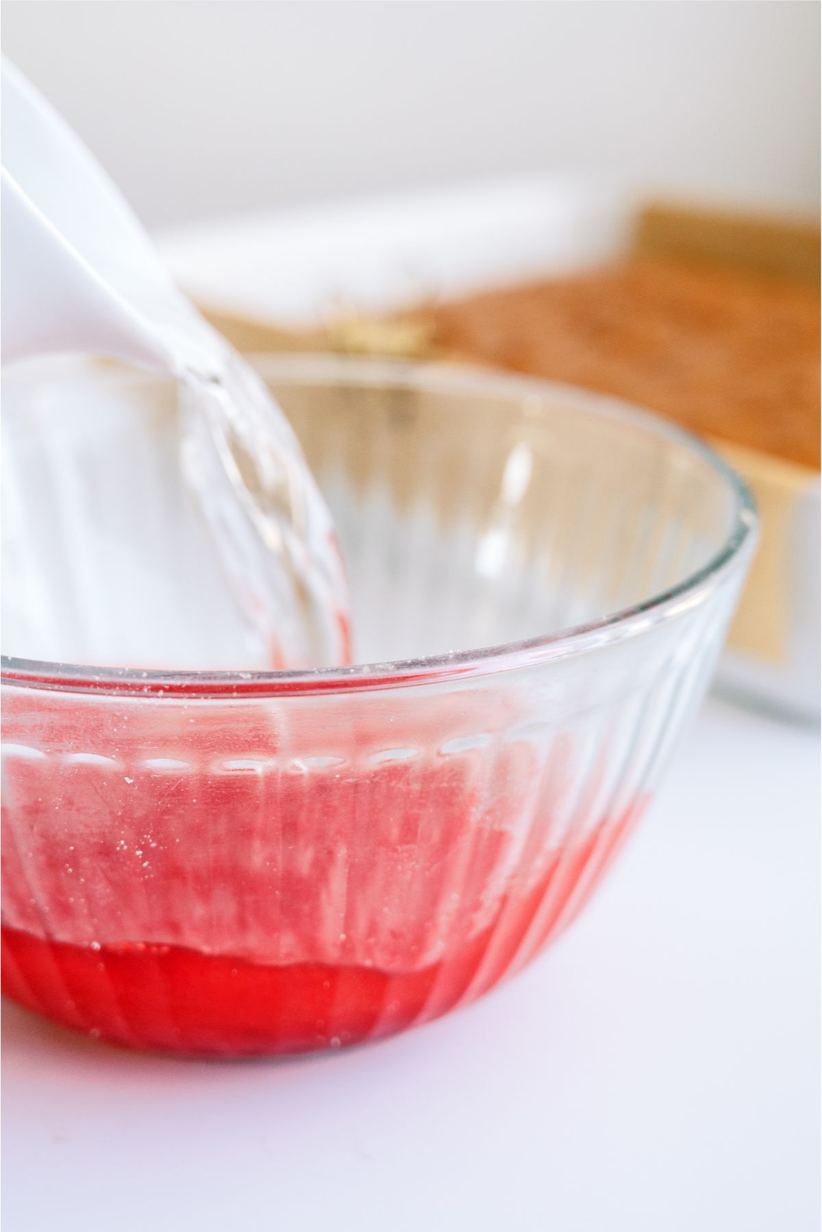 Hot water poured into a mixing bowl with jello mix