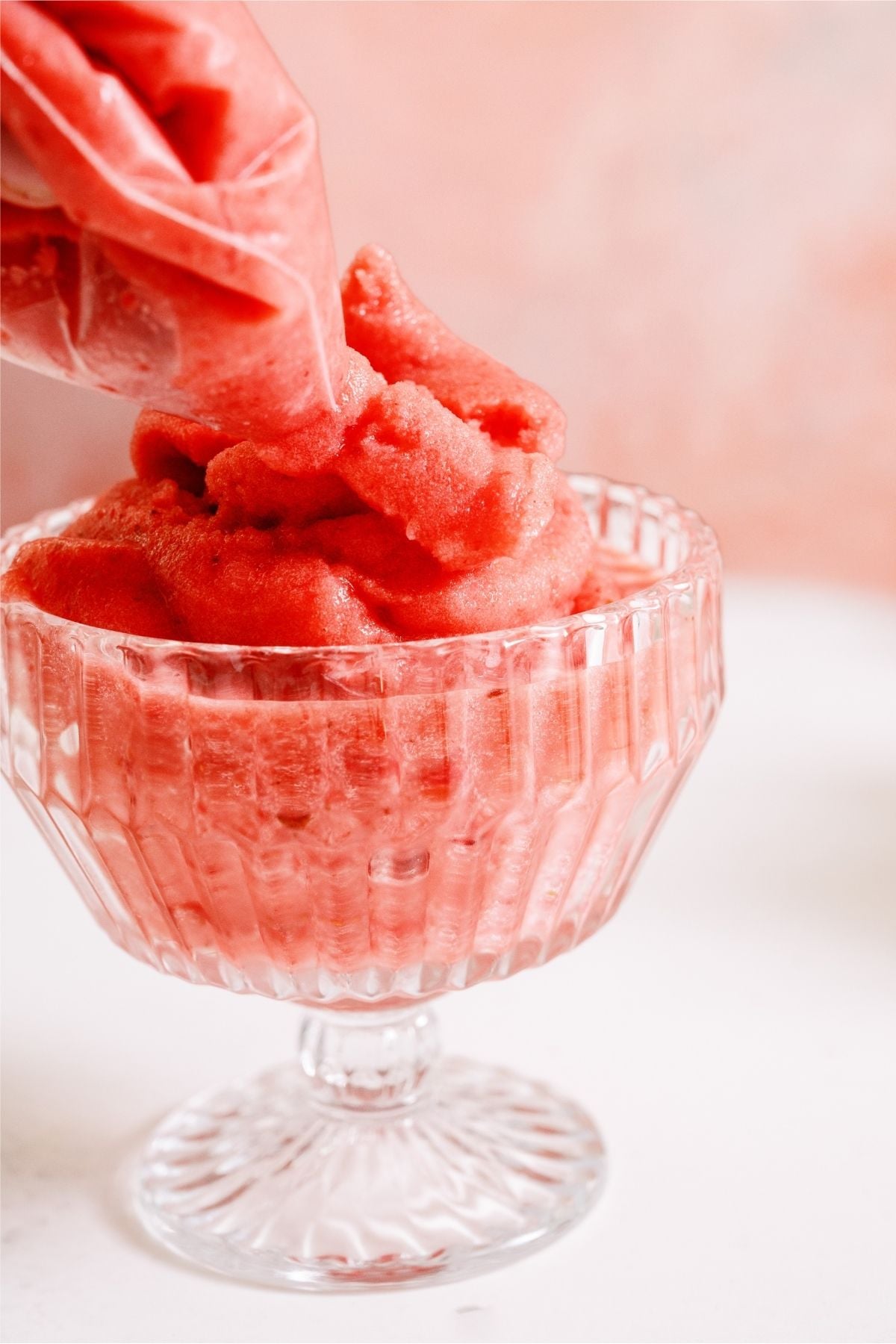 Ziploc bag swirling Strawberry Dole Whip into a glass.