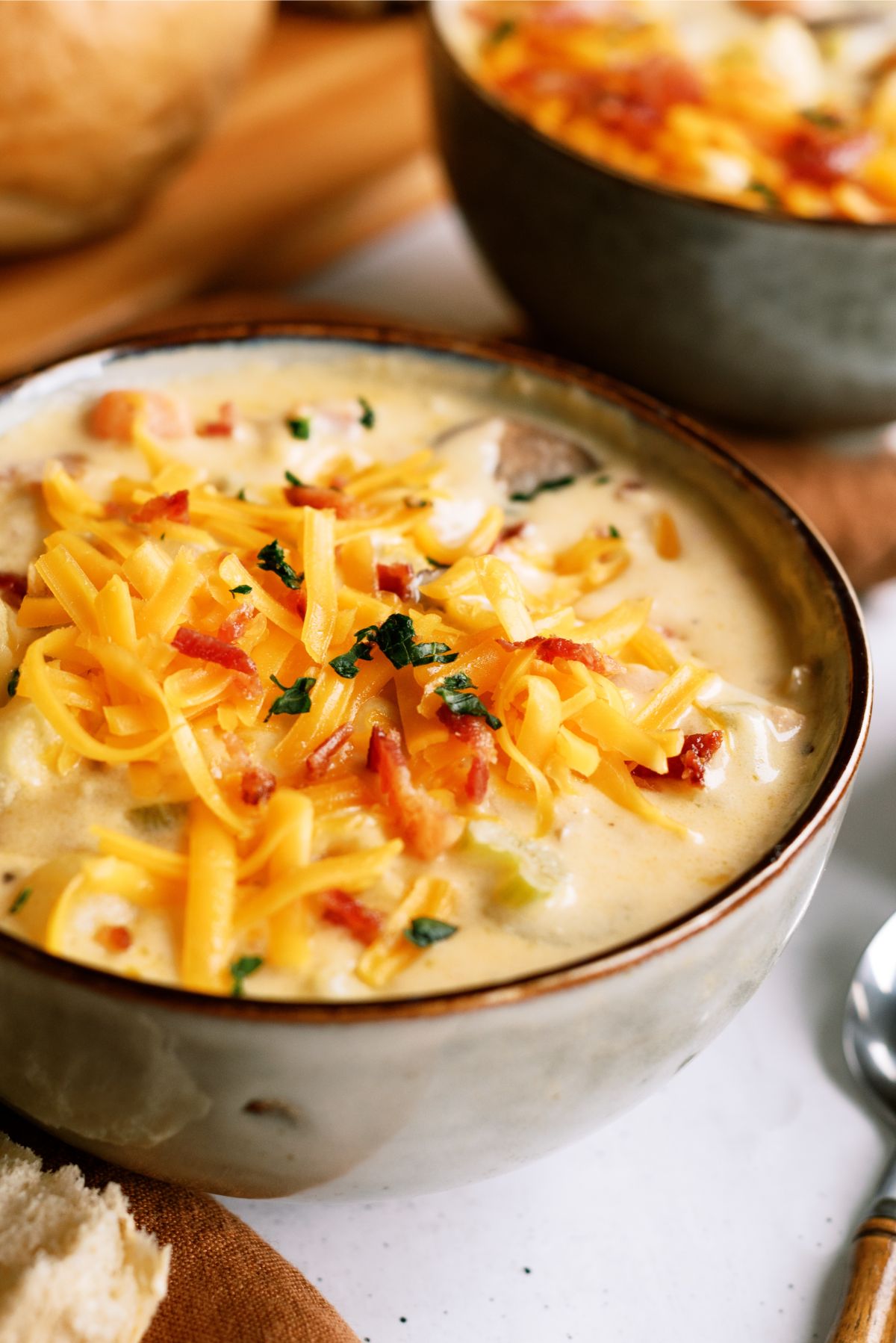 A bowl of Wisconsin Bacon And Potato Cheese Soup with toppings