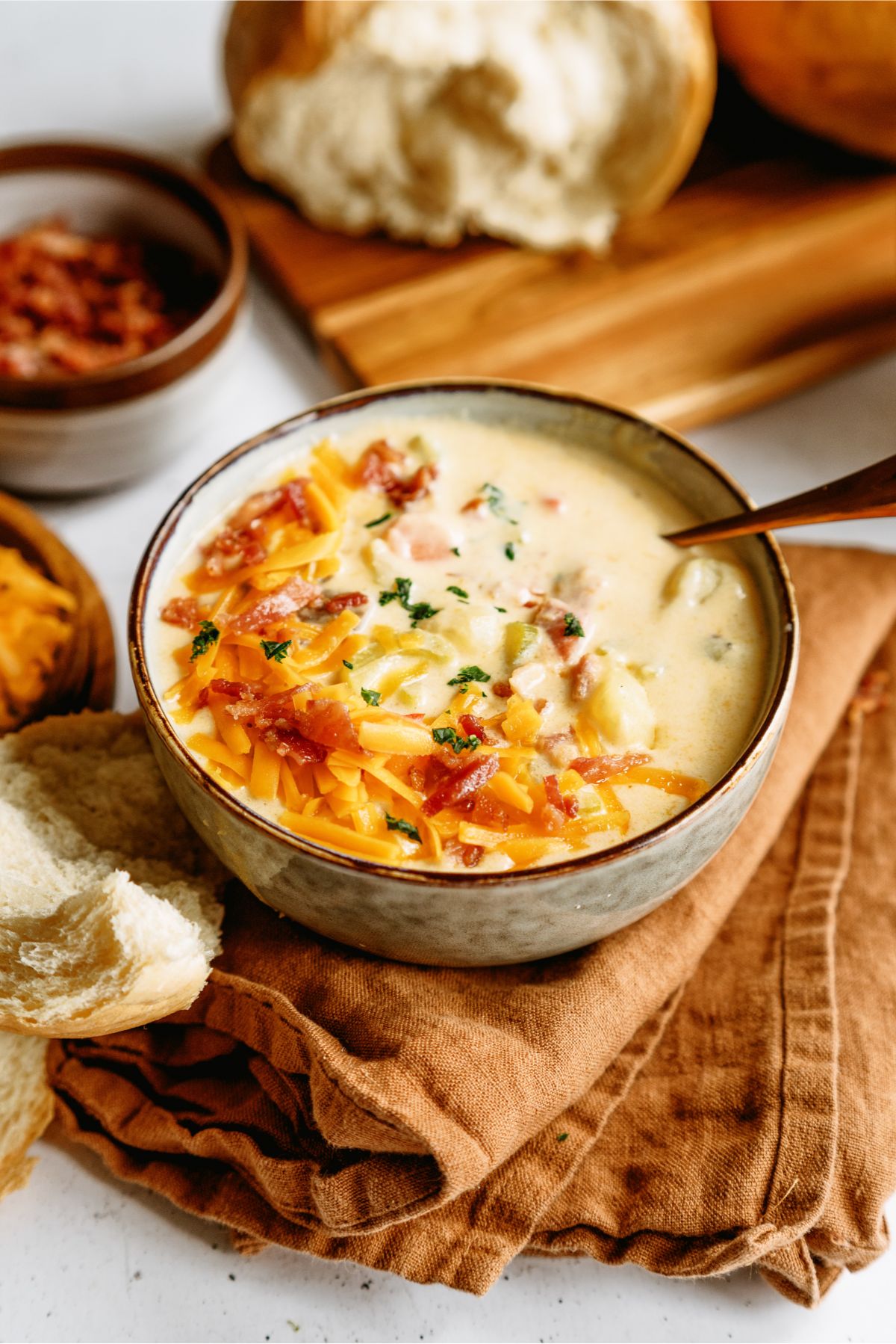 A bowl of Wisconsin Bacon And Potato Cheese Soup with toppings