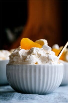 A small bowl of 5 Minute Fluffy Yogurt Fruit Salad with a spoon