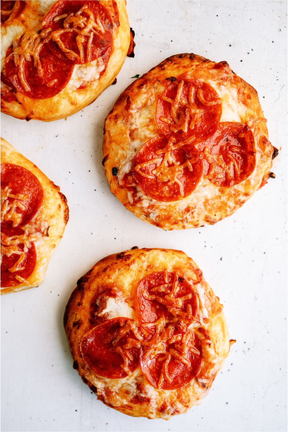 Air Fryer Pizzas on a counter topped with pepperoni