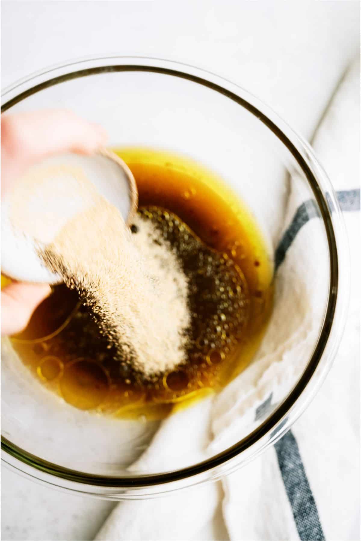 Adding brown sugar to marinade mixture in a bowl