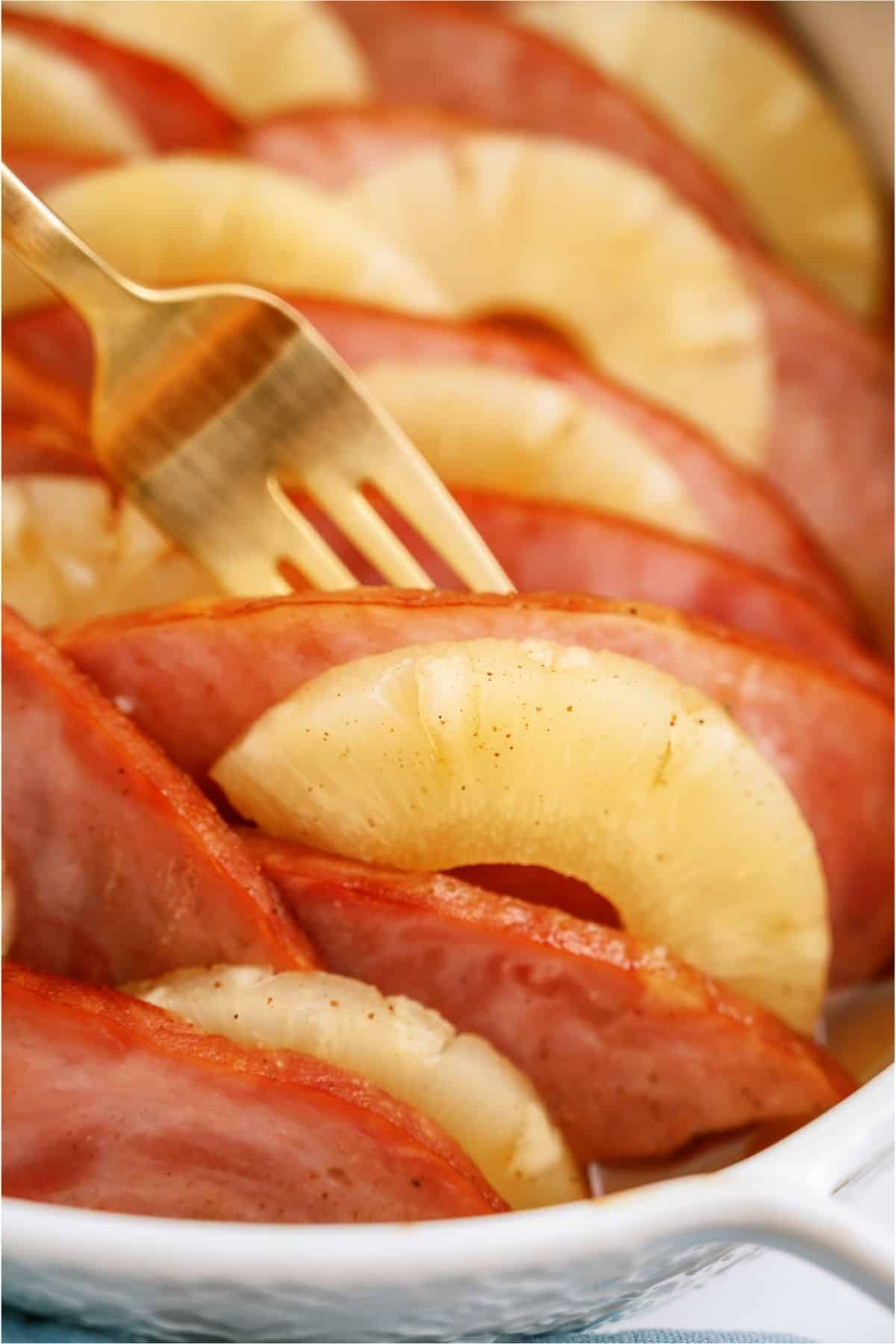 Close up of Ham and Pineapple Bake with a fork lifting out a piece of ham.