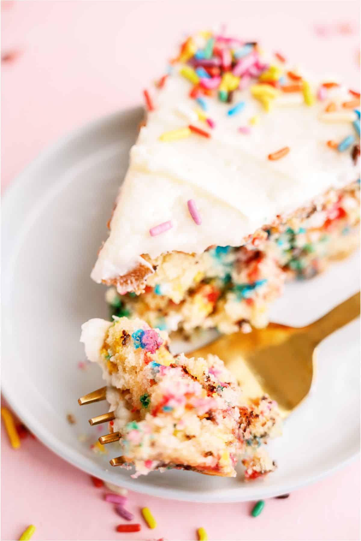 Close up of a slice of Homemade Funfetti Cake on a plate with a fork