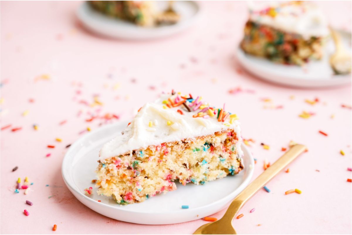 Slices of Homemade Funfetti Cake on small plates with forks